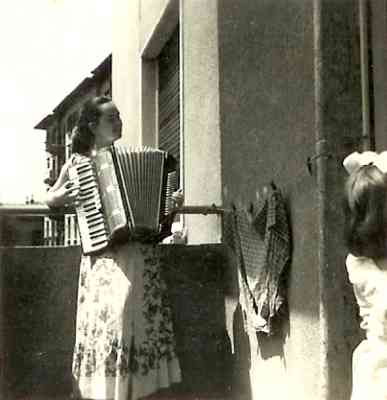 Louisa Yurman playing the accordion on the balcony of her apartment in Rijeka. Circa 1956-7.